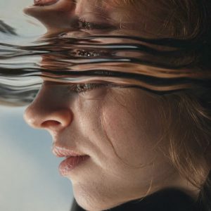 Distorted Reflections by Lisa Bayer, surreal fine art portrait of a woman’s face warped by water-like reflections