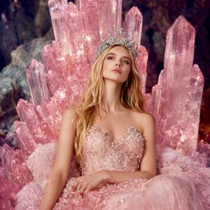 antasy artwork by Lisa Bayer of a crowned woman seated on a throne of glowing rose quartz crystals wearing a pink gown, symbolizing love, feminine power, and crystal energy.